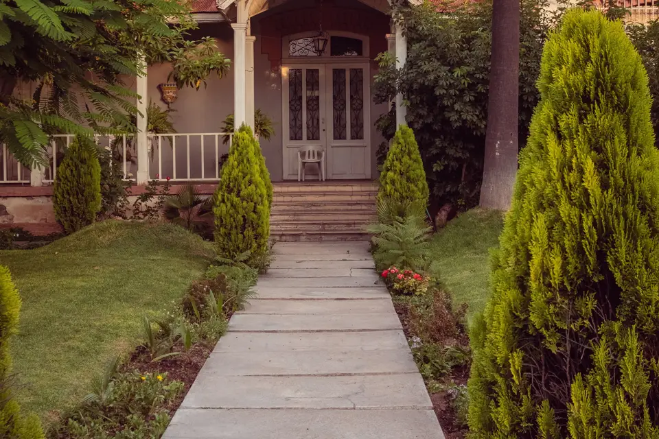 Jointed concrete walkway approaching a landscaped residential porch